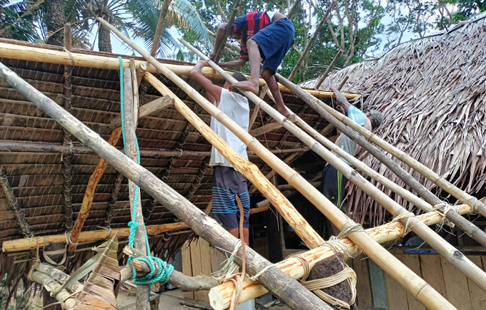 Working with bamboo structures and palm frond
thatch